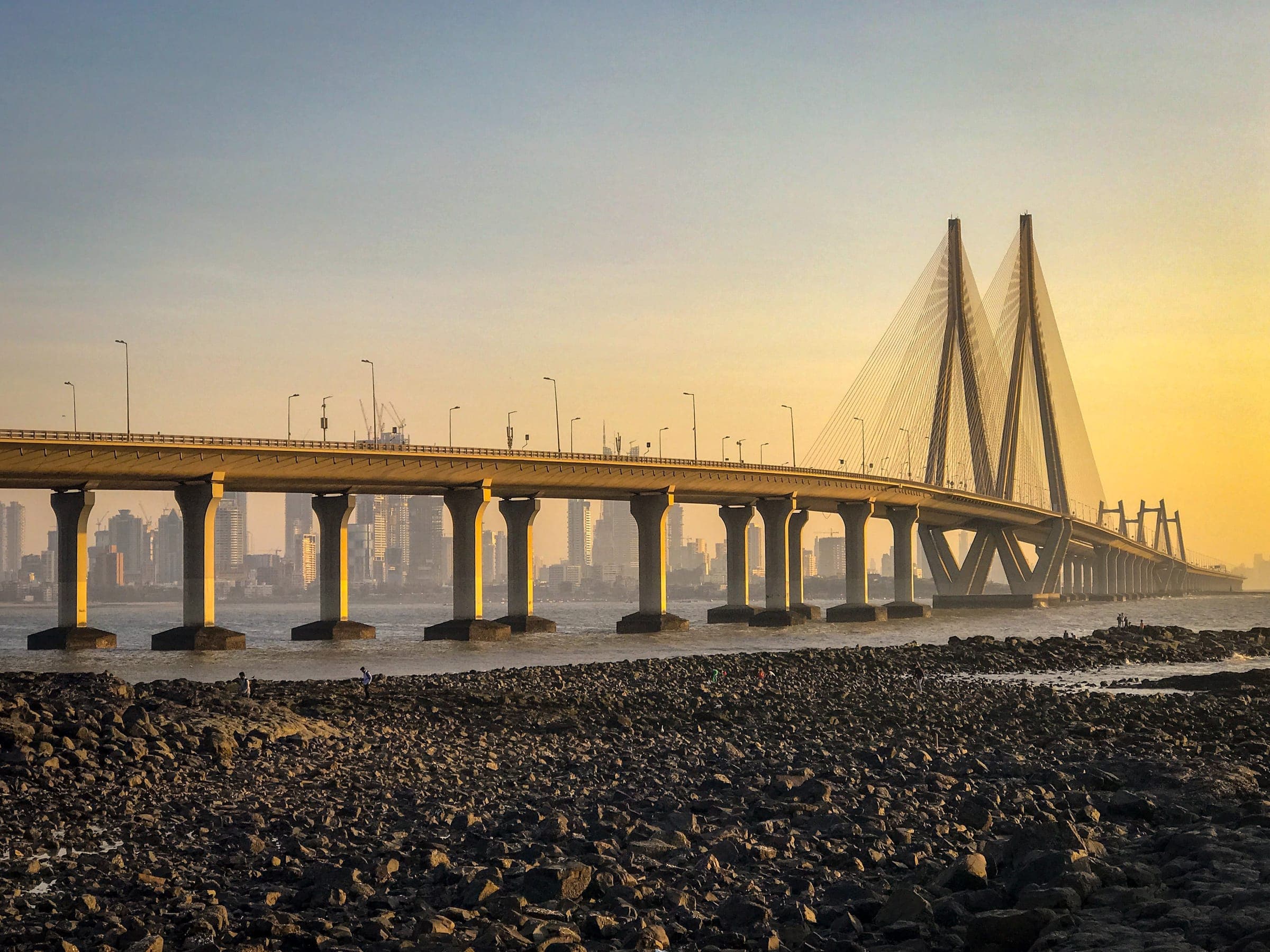 The Bandra–Worli Sea Link at golden hour, seen across the rocks