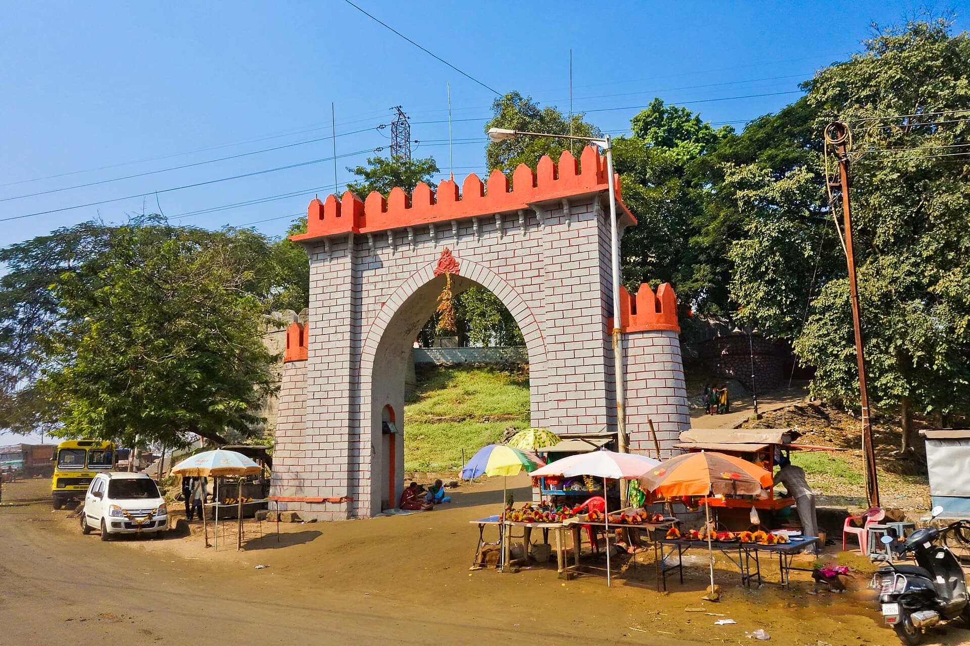 The stone gateway of Durgadi Fort in Kalyan, with red battlements against a blue sky