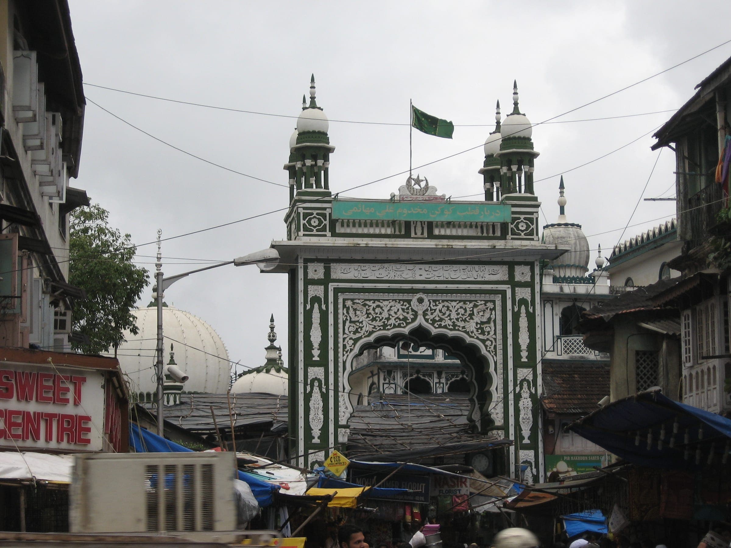 The green and white gateway of the Mahim Dargah, its flag flying